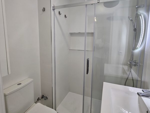 Plato de ducha con mampara de cristal en baño reformado