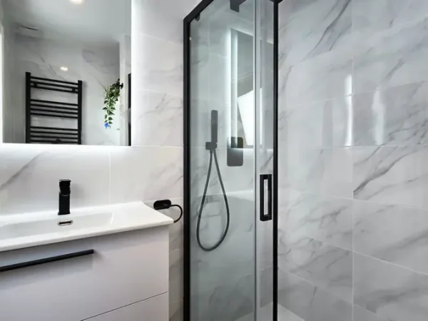 Baño en Tetuán con mármol negro y gris y espejo LED