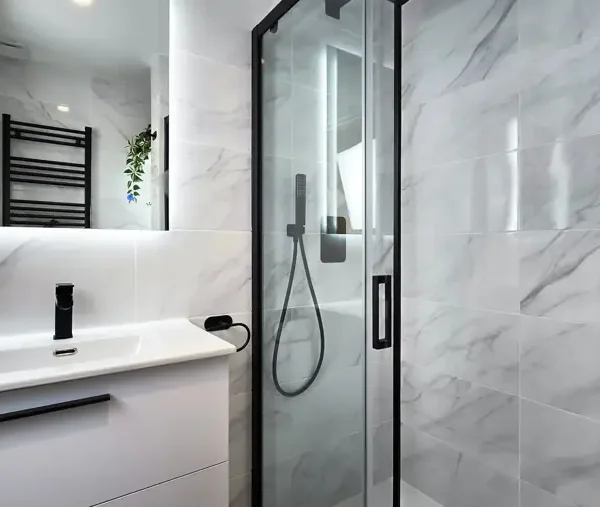 Baño en Tetuán con mármol negro y gris