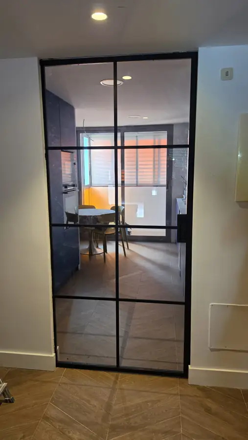 Puerta de cristal con perfilería negra en la cocina de Leganés